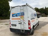 a van parked in a parking lot with a ladder on the back of it
