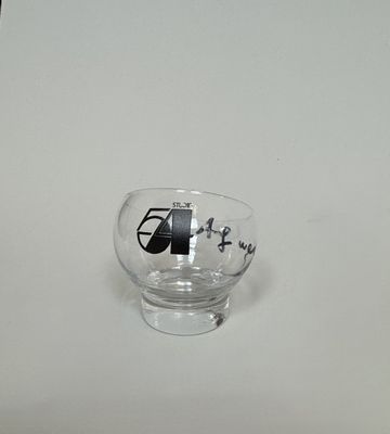 a small glass with a black and white picture on it