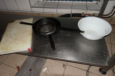 deux casseroles et un saladier posés sur une table dans une cuisine