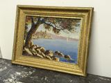 une peinture à l'huile représentant un arbre au bord de l'eau, dans un cadre doré
