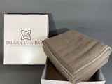 two folded towels in a white box on a gray surface