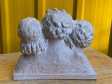 une statue représentant trois chiens assis sur une table en bois