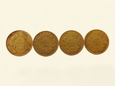trois pièces d'or posées côte à côte sur une surface blanche