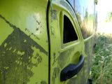 a close up of a yellow truck with a black door handle