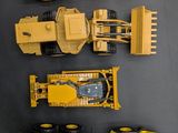 four different types of construction vehicles on the table