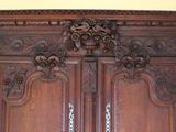 a wooden armoire with carvings on the top of it