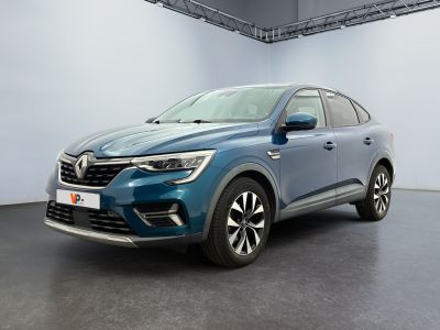 Une voiture bleue est garée dans une pièce blanche au sol noir.