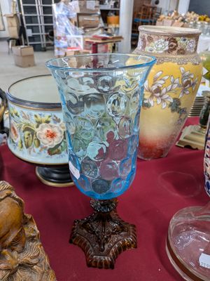 de nombreux vases posés sur une table recouverte d'une nappe rouge