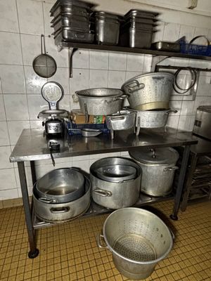 de nombreuses casseroles et poêles sur la table de la cuisine
