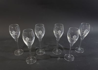 several empty wine glasses are lined up on a black surface