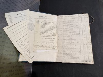 un livre ouvert posé sur une table, à côté d'une pile de papiers