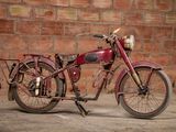 a red motorcycle that is parked in front of a brick wall