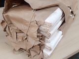 a brown paper bag on top of a stack of folded napkins