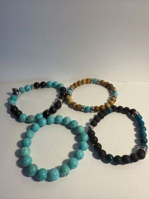 four bracelets of different colors and sizes on a white surface
