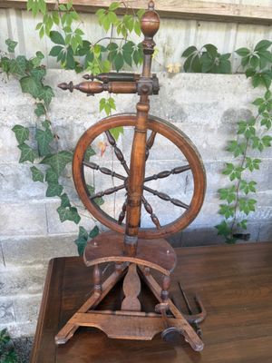 a spinning wheel on a wooden table in front of a brick wall