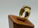 an image of a gold ring sitting on top of a wooden block