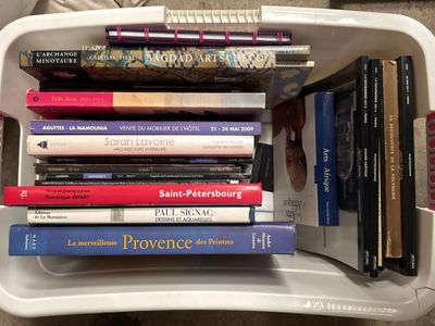 many books in a white container on the floor