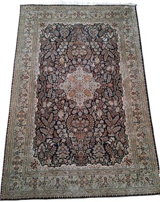un tapis persan antique avec un motif floral sur fond blanc