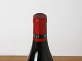 a bottle of wine sitting on a table next to a glass of wine
