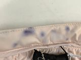 the back of a white jacket with a tag on it