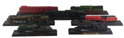 cinq trains miniatures exposés sur un fond blanc
