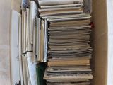 une boîte en carton remplie de journaux posée sur un lit