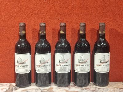 six bouteilles de vin sont alignées sur une table en marbre
