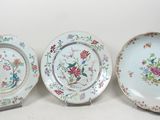 trois assiettes à motifs floraux posées sur une surface blanche