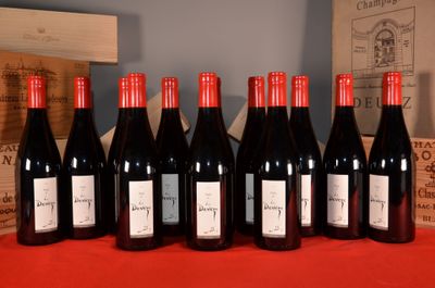 six bottles of red wine are lined up on a table