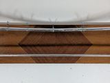a wooden tray with a metal bar on it