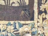 une personne debout devant une tenture murale sur laquelle est posé un tapis