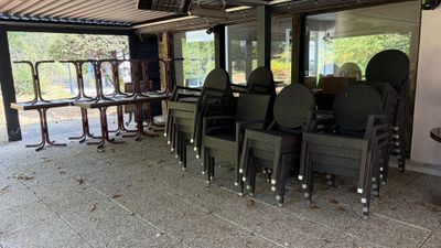 tables and chairs are lined up in a room with a metal roof