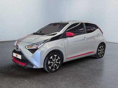 La Toyota AY est garée dans une pièce blanche au sol noir.