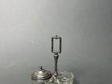 a small silver object with a handle on a table