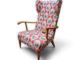 une chaise rembourrée dont l'assise est recouverte d'un tissu à motifs roses et bleus