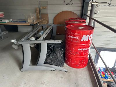 a red barrel sitting next to a chair in a garage
