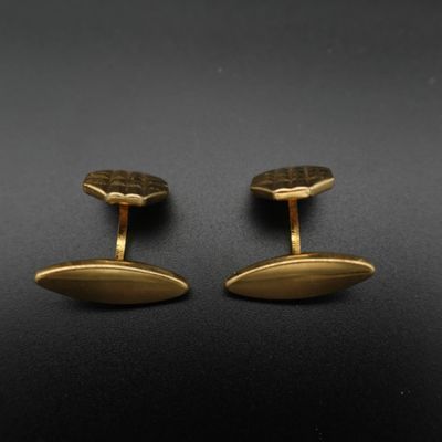 une paire de boutons de manchette en or sur fond noir