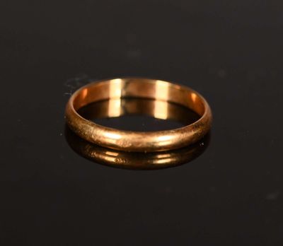 a gold wedding ring on a black surface