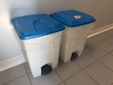 two trash cans sitting next to each other on the floor