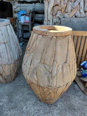two wooden vases sitting next to each other on a bench