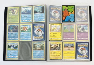 de nombreuses cartes Pokémon rangées dans un classeur posé sur la table