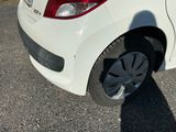 une petite voiture blanche garée sur le bord de la route