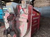 a large red machine that is sitting in the hay