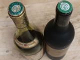 two bottles of wine sitting next to each other on a counter