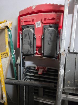 a ladder that is leaning against a wall next to a stack of chairs