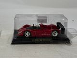 a red toy car in a clear case on a white surface