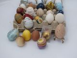 many different colored eggs in a carton on the table