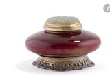 un vase rouge contenant une pierre verte