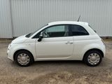 a picture of a small white car parked in front of a building