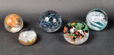 several glass marbles are lined up on a black surface